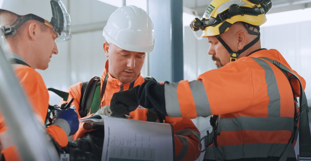 Engineers in hard hats and hi-vis checking equipment